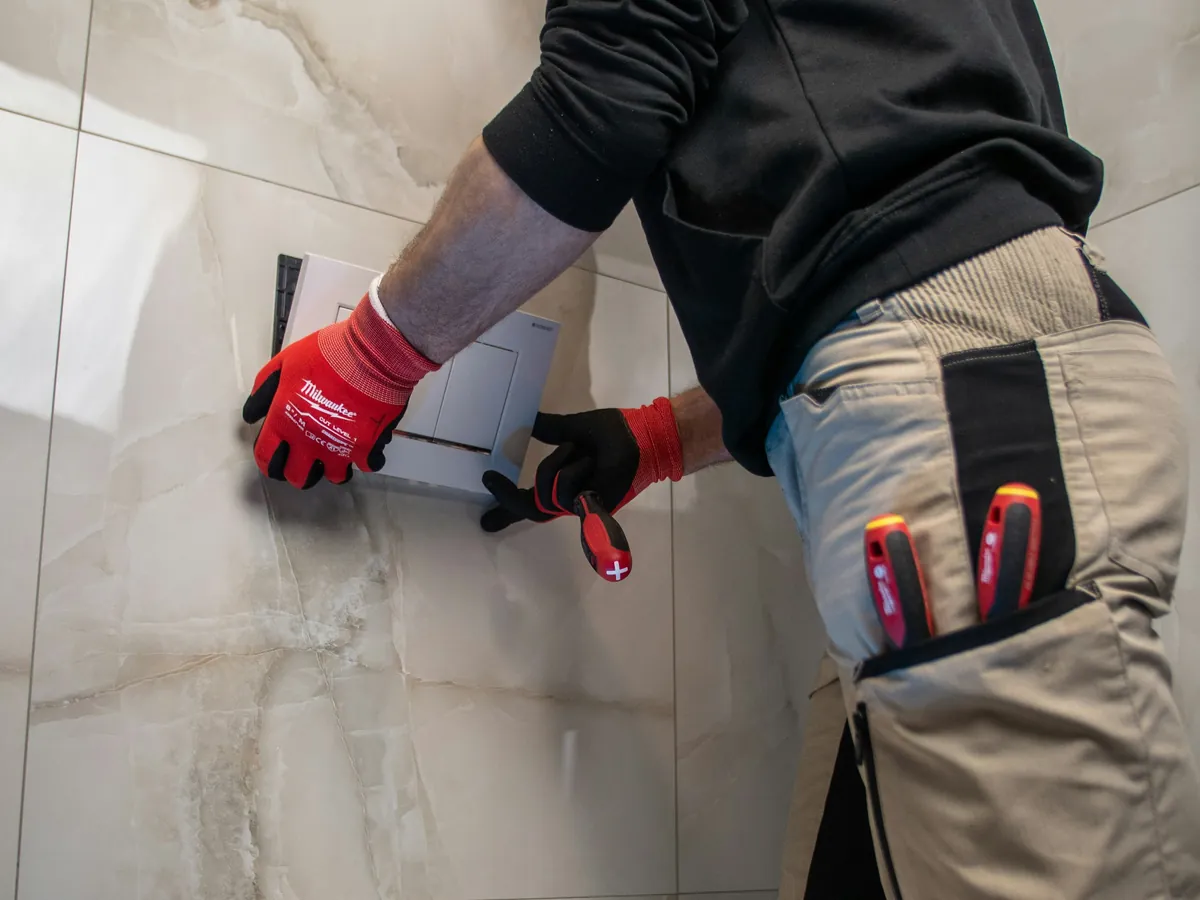 Técnico con guantes trabajando en la instalación de un baño